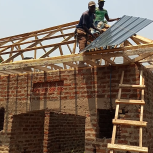 Nailing of the first iron sheet at the house 